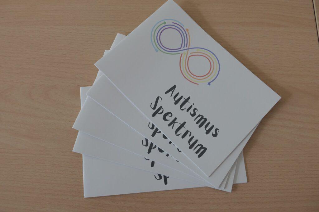 Flyer with colorful infinity sign and a writing reading Autismus Spektrum