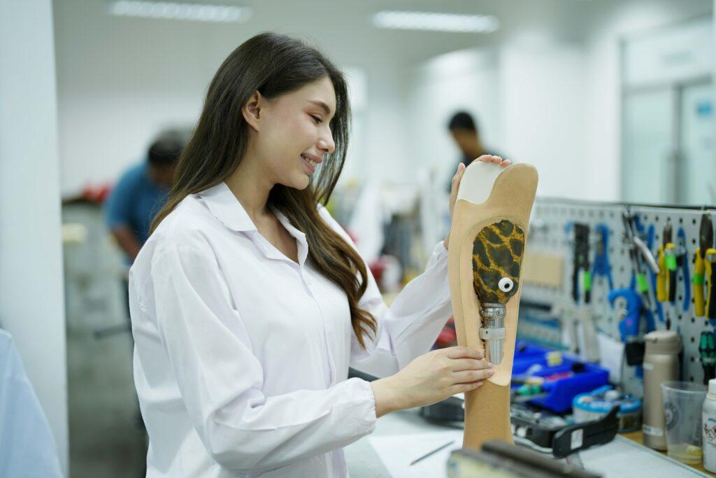 Orthopedic technician making prosthetic leg for disabled people in workshop.